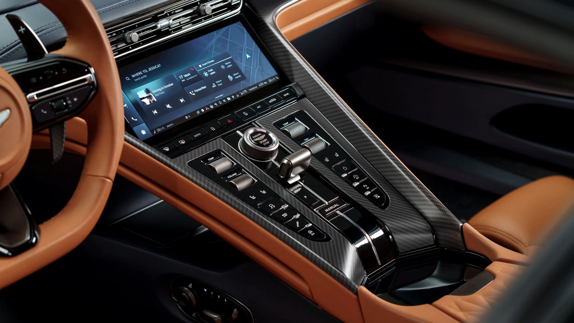 Aston Martin centre console with rows of physical switches, the rotary controller and the infotainment touchscreen above.