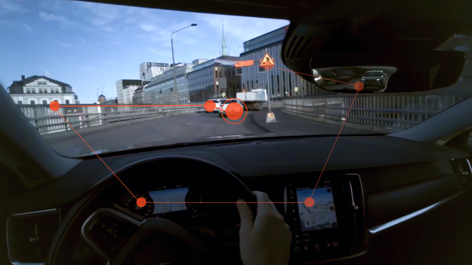 A driver's view of the road with eye-tracking points and lines plotted between the windscreen, the instrument cluster and the centre screen.