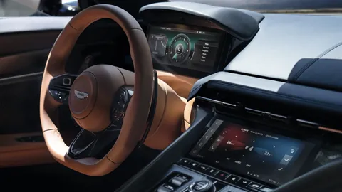 Aston Martin steering wheel in front of the digital instrument cluster, with the climate screen below.